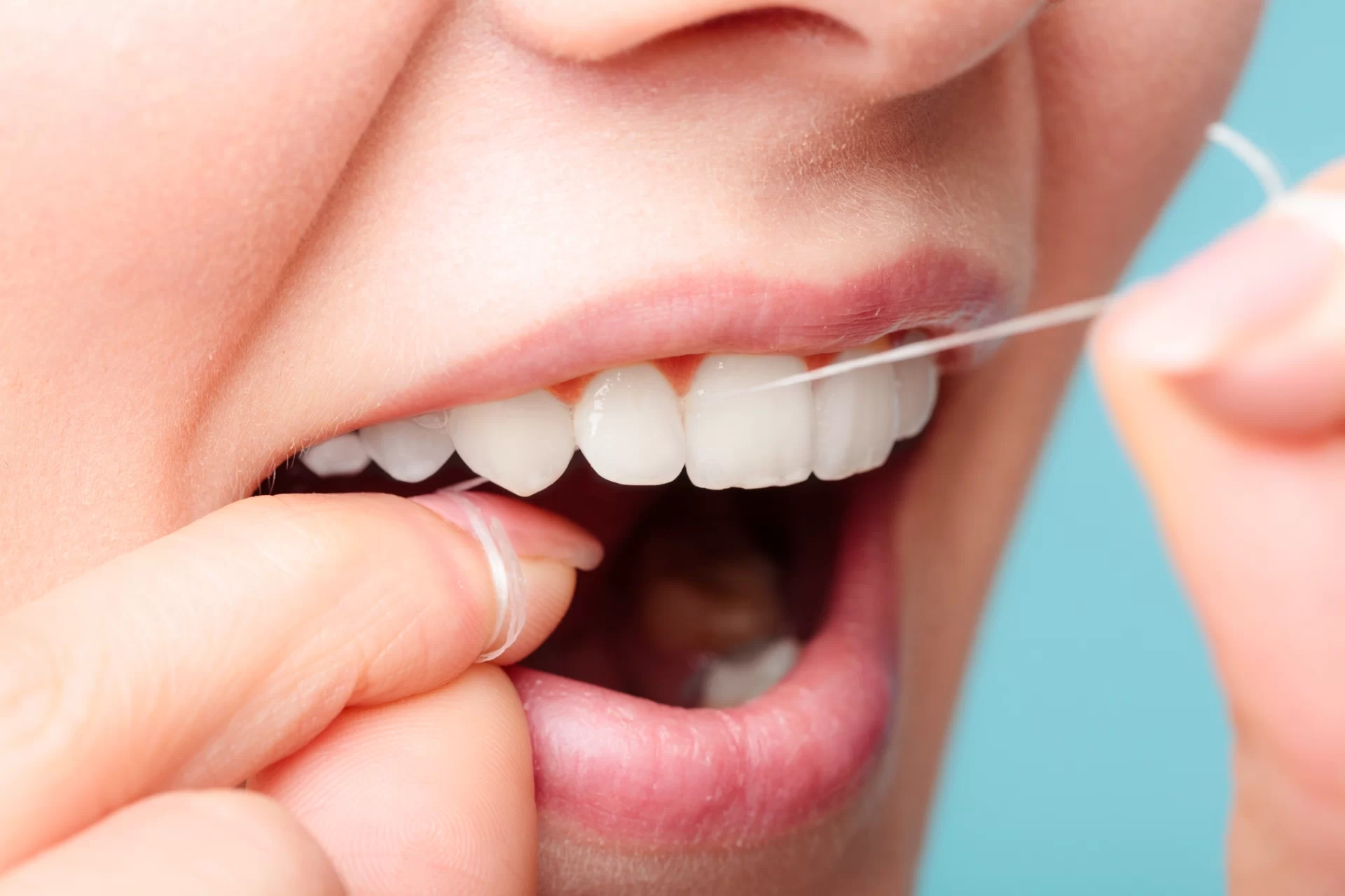 close up of woman flossing teeth